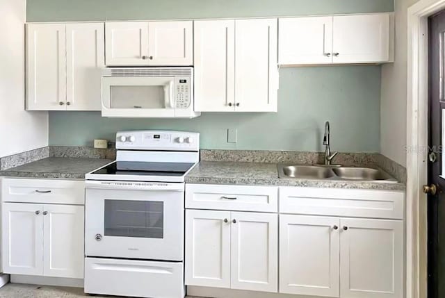 kitchen with white cabinetry, sink, and white appliances