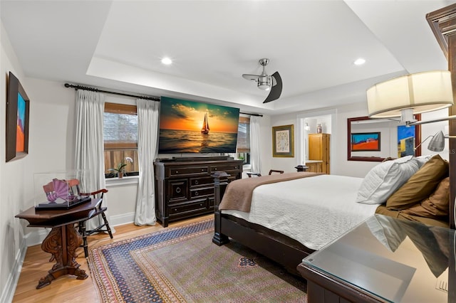 bedroom with hardwood / wood-style flooring and a raised ceiling