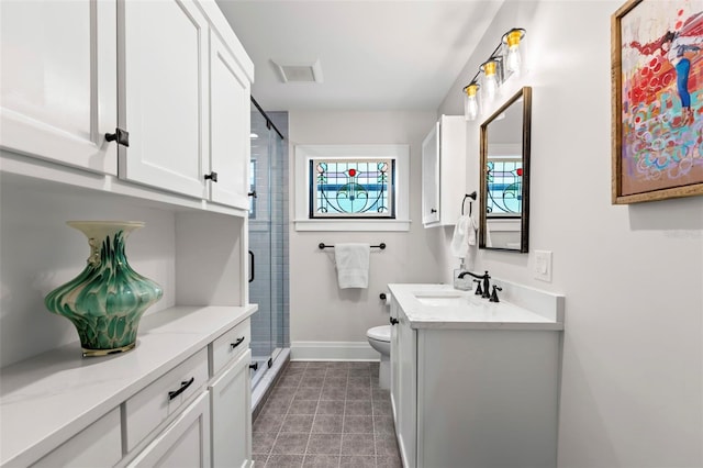 bathroom featuring vanity, walk in shower, tile patterned floors, and toilet