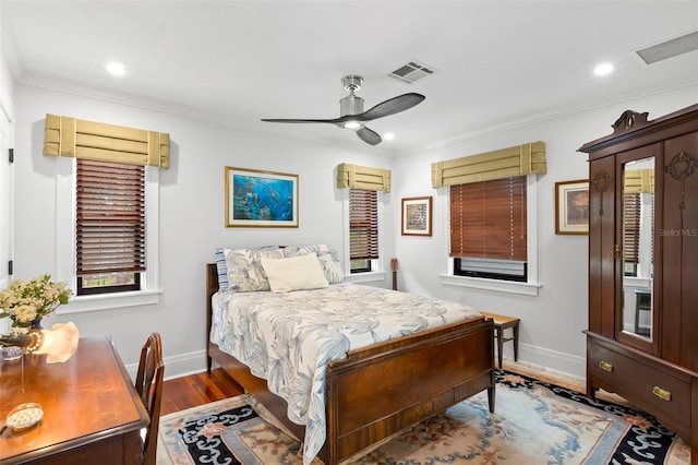 bedroom with hardwood / wood-style flooring, ornamental molding, and ceiling fan