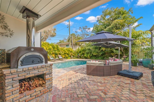 view of swimming pool with a patio and an outdoor living space with a fireplace