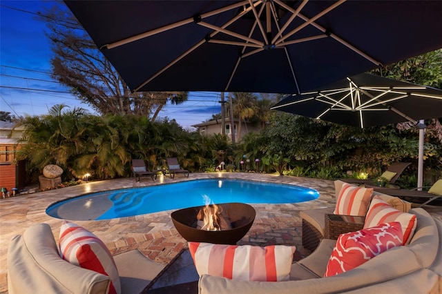 view of swimming pool featuring an outdoor living space with a fire pit and a patio area