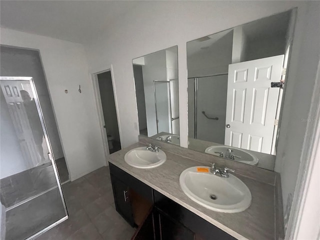 bathroom with vanity, toilet, and a shower with door