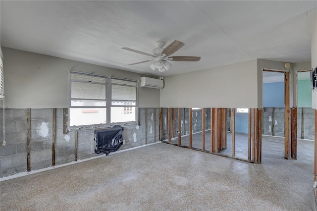 unfurnished room featuring a wall unit AC and ceiling fan