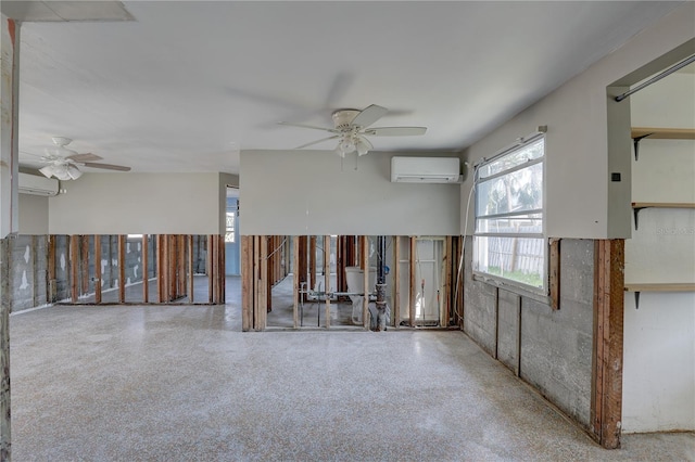 unfurnished room featuring a wall mounted air conditioner and ceiling fan