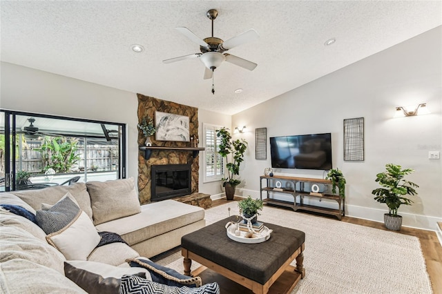 living room with wood-type flooring, vaulted ceiling, a textured ceiling, and a wealth of natural light