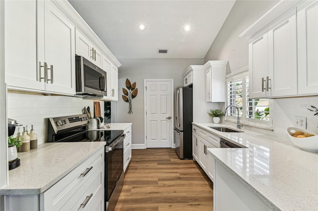 kitchen featuring stainless steel appliances, sink, white cabinets, and light stone counters