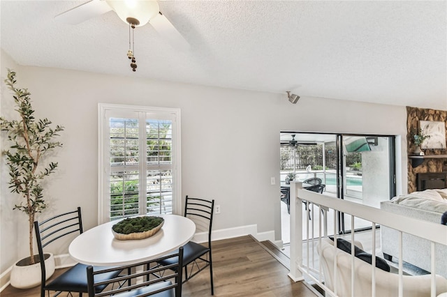 dining room with ceiling fan, hardwood / wood-style floors, and a textured ceiling