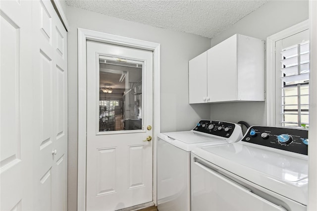 washroom featuring independent washer and dryer, cabinets, and a textured ceiling