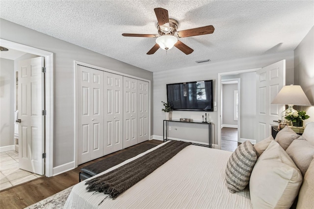 bedroom featuring hardwood / wood-style flooring, ceiling fan, a textured ceiling, and a closet