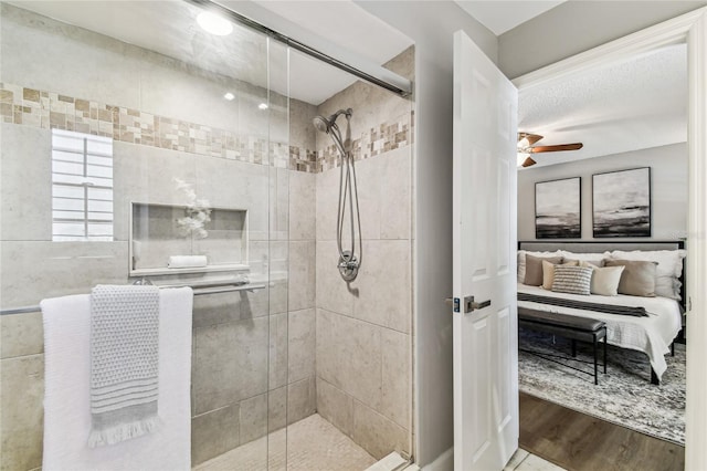 bathroom with hardwood / wood-style flooring, ceiling fan, and walk in shower