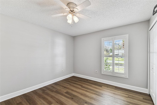 empty room featuring ceiling fan, a textured ceiling, and dark hardwood / wood-style flooring