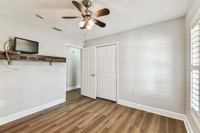 unfurnished bedroom with hardwood / wood-style flooring, ceiling fan, a textured ceiling, and a closet