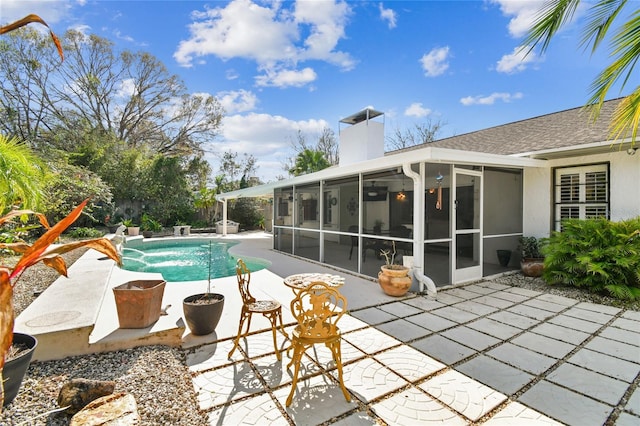 view of swimming pool featuring a patio area and a sunroom