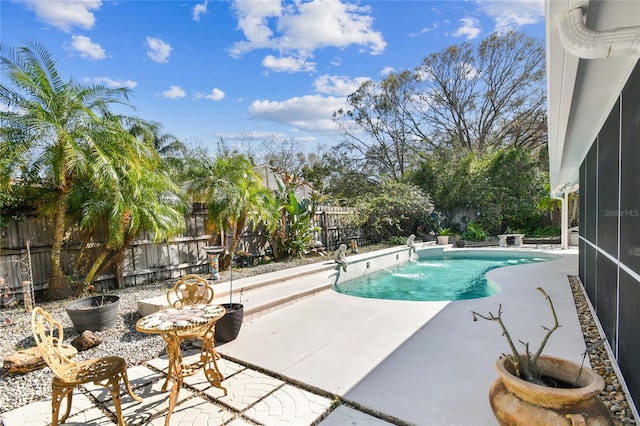 view of swimming pool featuring a sunroom and a patio area