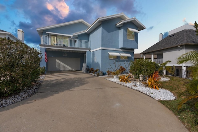 view of front facade featuring a garage and a balcony