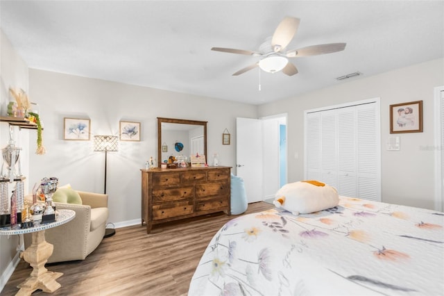 bedroom with ceiling fan, wood-type flooring, and a closet