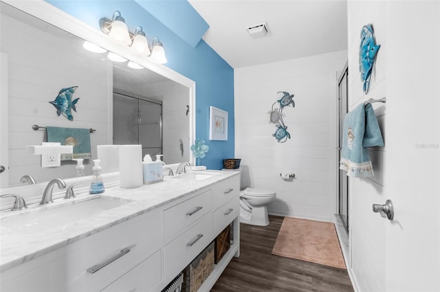 bathroom featuring vanity, hardwood / wood-style flooring, a shower with shower door, and toilet