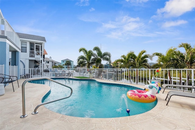 view of swimming pool with a water view and a patio