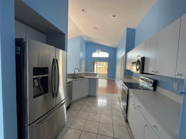 kitchen with sink, white cabinetry, decorative light fixtures, light tile patterned floors, and stainless steel appliances