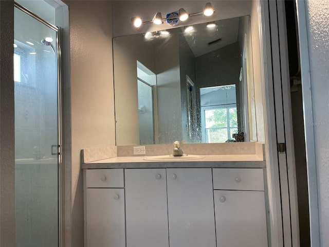 bathroom featuring vanity and a shower with shower door