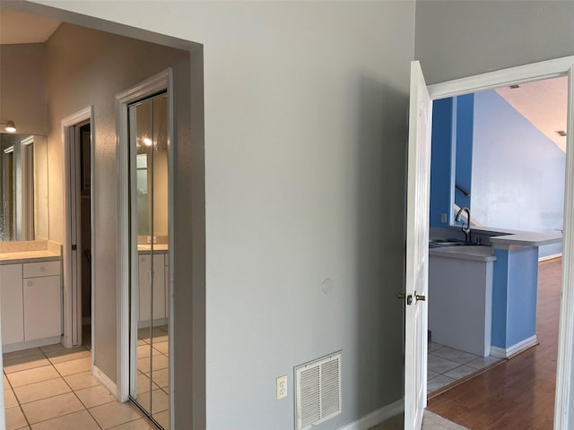 corridor with sink and light tile patterned flooring