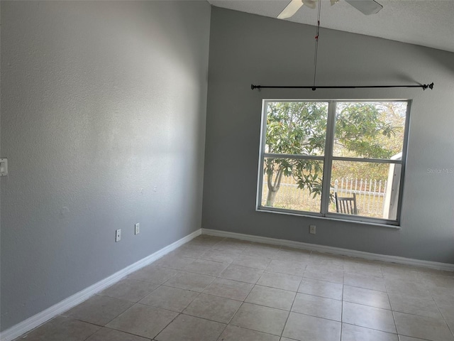 tiled spare room with ceiling fan and vaulted ceiling