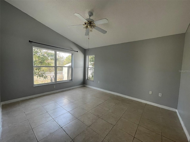 tiled spare room with a textured ceiling, vaulted ceiling, and ceiling fan