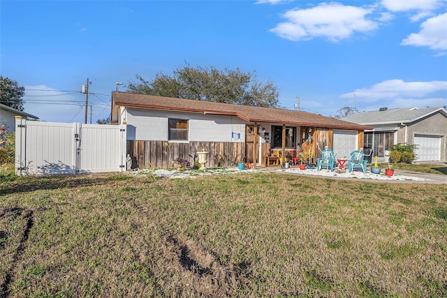 ranch-style home featuring a garage and a front lawn