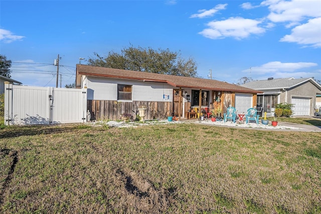 ranch-style home with a garage and a front lawn