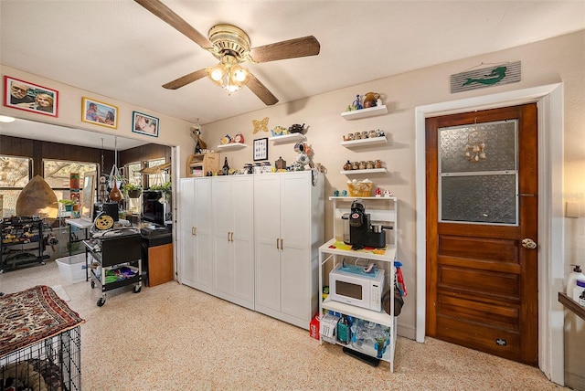 interior space with ceiling fan