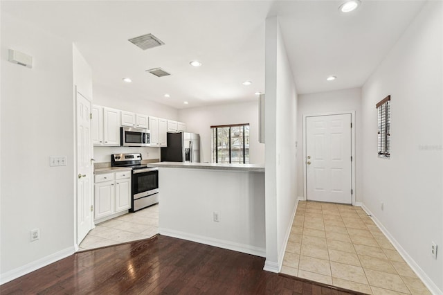 kitchen featuring white cabinetry, stainless steel appliances, and light hardwood / wood-style floors