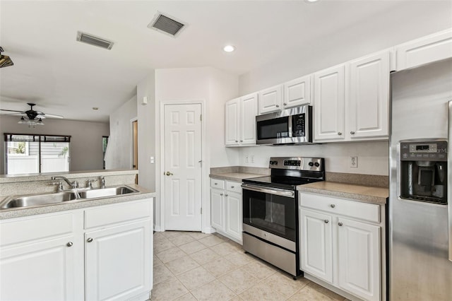 kitchen with white cabinetry, sink, stainless steel appliances, and ceiling fan