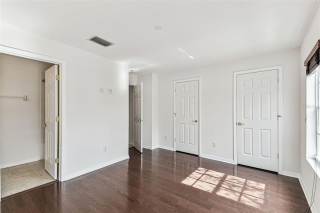 unfurnished bedroom with dark wood-type flooring