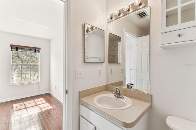 bathroom with vanity, hardwood / wood-style floors, and toilet