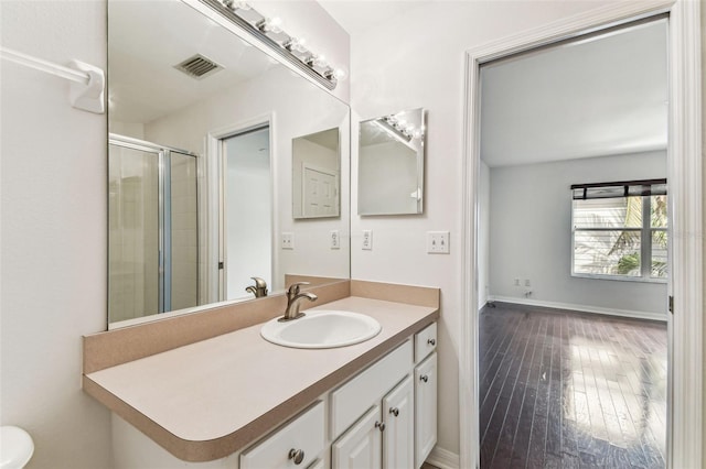 bathroom featuring wood-type flooring, a shower with door, and vanity