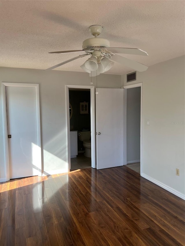 unfurnished room featuring ceiling fan, a textured ceiling, and dark hardwood / wood-style flooring