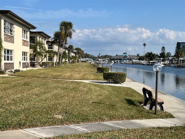 view of home's community with a water view and a yard