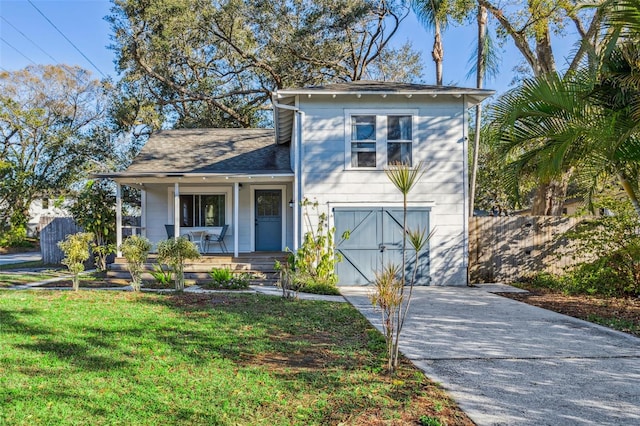 view of front of home featuring driveway, a porch, roof with shingles, a front yard, and a garage