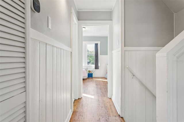 hall featuring light wood finished floors and wainscoting