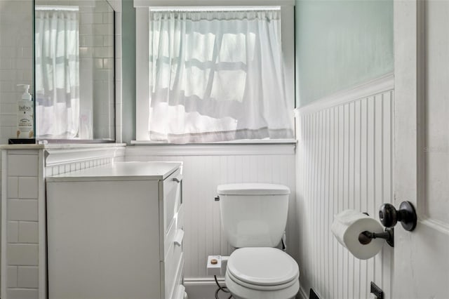 bathroom with a wainscoted wall and toilet