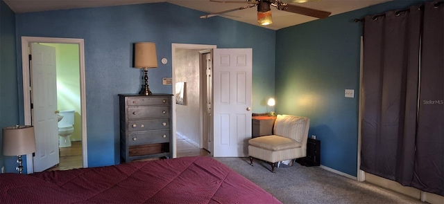 bedroom with lofted ceiling, carpet flooring, and ensuite bath