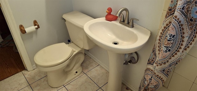 bathroom featuring toilet and tile patterned flooring