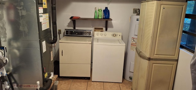 clothes washing area featuring independent washer and dryer, electric water heater, heating unit, and light tile patterned floors