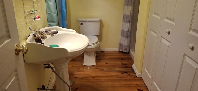 bathroom with a shower with curtain, wood-type flooring, and toilet