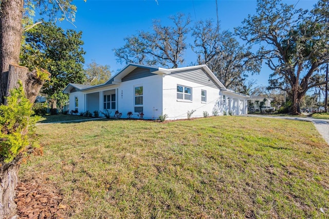 view of front facade featuring brick siding, driveway, an attached garage, and a front lawn