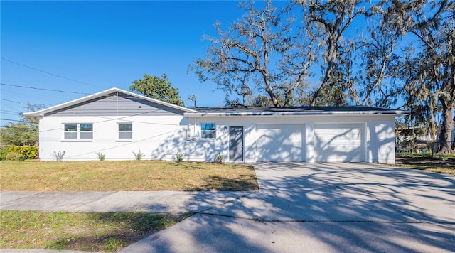 single story home featuring a garage, driveway, and a front yard