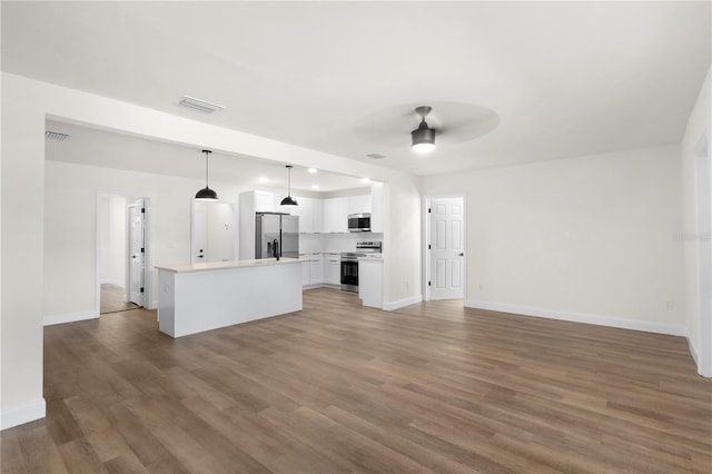 unfurnished living room with visible vents, baseboards, ceiling fan, and wood finished floors