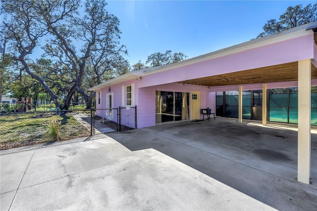 back of house featuring a carport, driveway, and fence