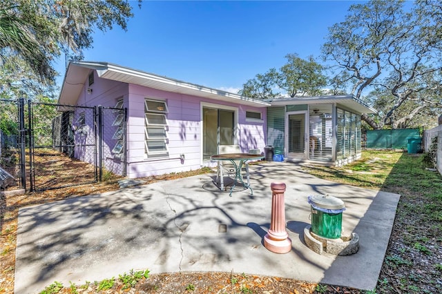 rear view of house featuring a patio, fence private yard, and a gate